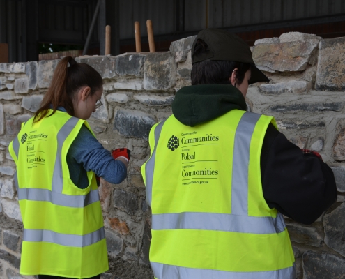 Women building a stone wall.