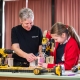 An adult woman and a girl looking at power tools.